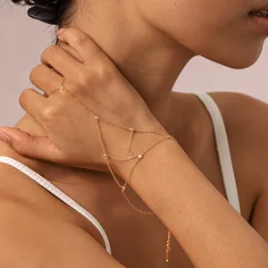 Gros plan d'un délicat bracelet de doigt en or relié avec des pierres de zircone brillantes.