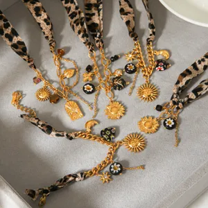 Detailed view of DIY leopard print fabric ribbon and gold chain necklace bracelet set charms.