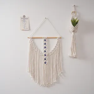 Tenture murale macramé bohème avec perles œil bleu et franges pour belle décoration intérieure.