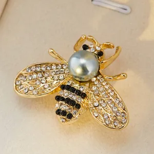 Gros plan détaillé d'une broche abeille de luxe avec strass, perles et finition dorée.