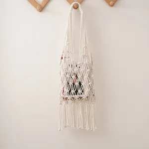 Handmade macrame cotton net grocery bag hanging detail shot, eco-friendly reusable fruit storage bag.