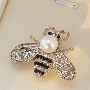 Gros plan détaillé d'une broche abeille en strass étincelant dotée d'une tête en perle et cristaux.