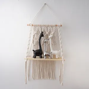 Bohemian macrame wall hanging shelf with wooden board and cute animal figurines for decor.