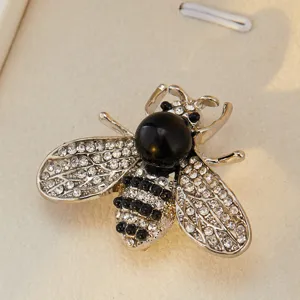 Vue détaillée d'une broche abeille élégante ornée de strass scintillants et perle.
