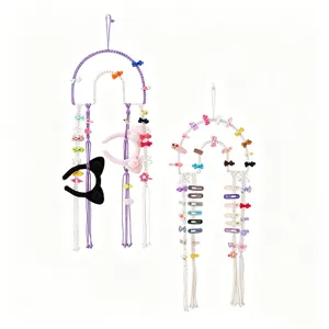 Detailed view of handmade woven cotton macrame hair clip wall hanging organizer with bows.