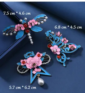Gros plan sur les détails des broches florales en émail chinois traditionnel avec perles.
