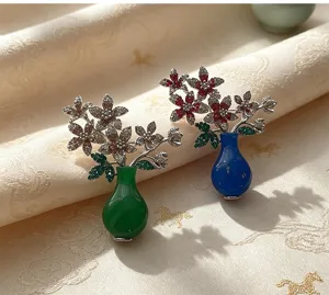 Exquisite vintage style vase brooch featuring sparkling rhinestones and floral design.