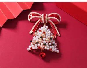 Christmas pearl bow brooch with red enamel and bell, festive holiday clothing accessory pin gift.