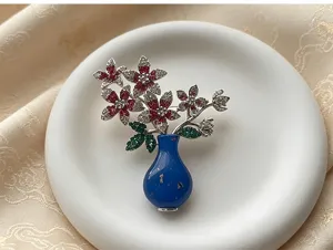 Detailed close-up of a delicate blue vase flower brooch adorned with sparkling rhinestones.