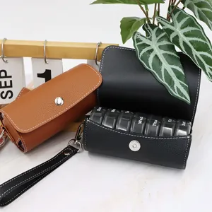 Weekly 7-compartment pill organizer with PU leather protective case and wrist strap.