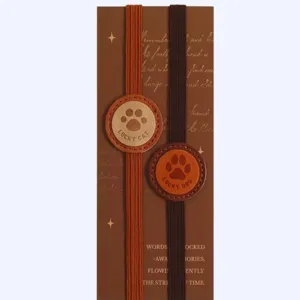 Detailed view of elastic PU leather book marker showing the cute paw print patch and backing card.