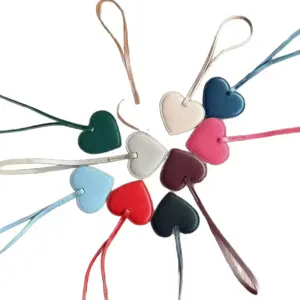 Primer plano de dijes para bolsos y llaveros de cuero PU en forma de corazon de colores.
