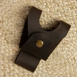 Dark brown leather axe sheath detail showing metal snap button for outdoor camping safety.