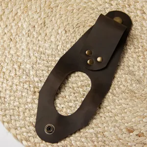 Close-up of brown leather axe sheath with metal rivets, durable outdoor tool storage accessory.