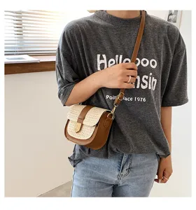 Model trägt eine gewebte Patchwork-Satteltasche mit braunen Lederakzenten und Riemen