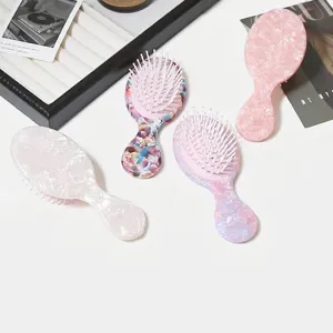 Vista dettagliata delle mini spazzole per capelli con motivi marmorizzati in vari colori