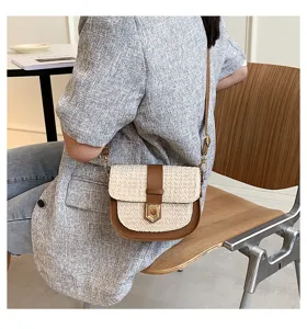 Modische gewebte Stroh-Satteltasche mit braunem Lederbesatz, am Modell präsentiert
