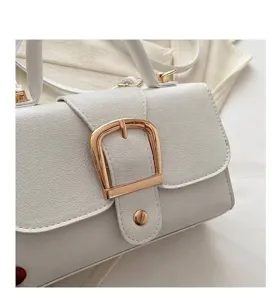 Detailansicht der goldenen Schnalle an einer weißen minimalistischen kleinen Handtasche