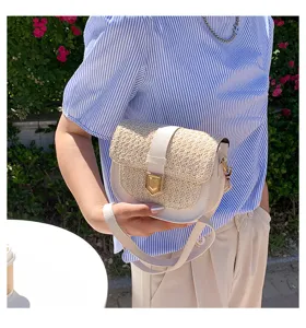 Sommerliche Lifestyle-Ansicht einer gewebten Stroh-Satteltasche mit weißem Leder.