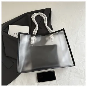 Detail der transparenten PVC-Tragetasche mit weißen Seilgriffen und schwarzer Tasche