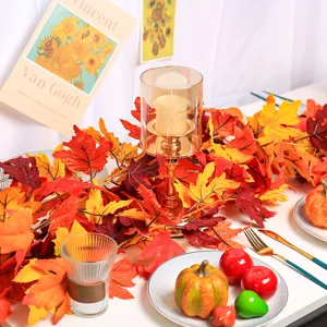 Autumn artificial maple leaf garland displayed with festive candles and pumpkins