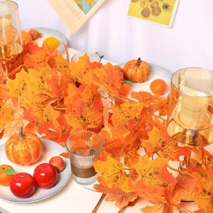 Close-up detail of vibrant orange artificial autumn maple leaf garland festive decorations
