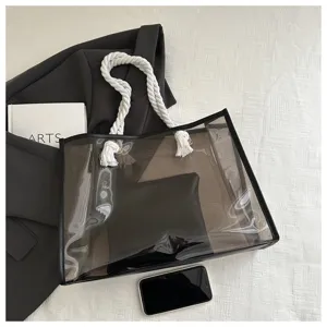 Detailaufnahme der transparenten PVC-Tragetasche mit Seilgriffen und schwarzer Innentasche.