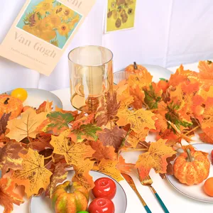 Detailed close-up of artificial autumn maple leaf garland with festive pumpkin decor