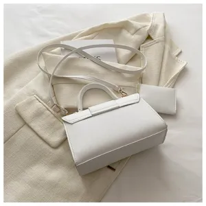 Minimalistische weiße quadratische Umhängetasche und kleine Pouch auf Blazer
