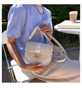 Elegante geflochtene Satteltasche in Cremeweiß für einen sommerlichen Tag im Freien.