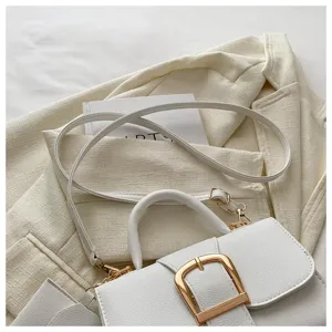 Detailaufnahme einer weißen minimalistischen Retro-Handtasche mit goldener Schnalle