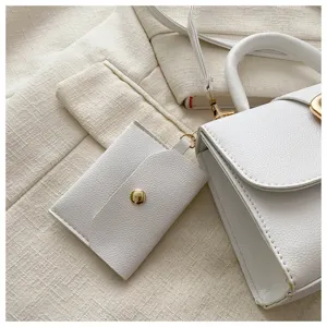 Detailaufnahme der weißen Handtasche mit Lychee-Struktur und Mini-Münzgeldbörse