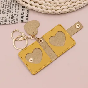 Minimalist yellow leather mini photo keychain with heart-shaped window, cute bag charm.