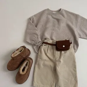 Kinder Freizeit Outfit Set mit Beige Sweatshirt, Hose mit Retro Taillentasche und warmen Stiefeln.