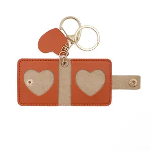 Detailed close-up of mini leather photo keychain with heart cutout and metal rings.