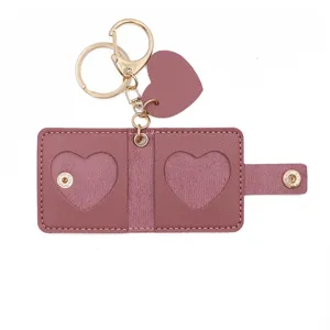 Mini leather photo keychain with cute heart cutout and metal rings for storing pictures.
