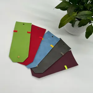 Detail view of colorful leather wrap wallets with magnetic snap buttons and elastic bands.