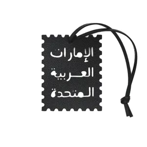 Colgante de bolso de cuero negro en forma de sello con texto árabe recortado elegante.