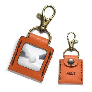 Leather photo album keychain detail, square mini picture frame pendant with bronze clasp.