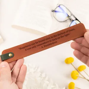 Detailed view of brown PU leather bookmark with quote engraving and metal rivet.