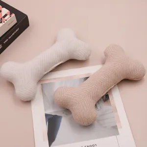Close-up view of fabric bone pet toy, showcasing soft herringbone texture and fine stitching details.