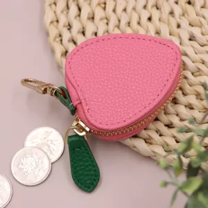 Primo piano dettaglio del portamonete in PU a forma di fragola rosa e cerniera.