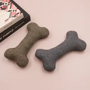 Close-up of herringbone fabric bone pet toys in green and grey, featuring soft textured details.