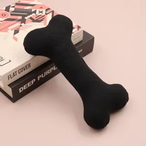 Close-up view of the black bone-shaped plush dog toy showing fabric texture.