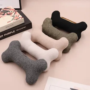 Close-up detail of assorted colored knitted bone-shaped pet toys neatly arranged on surface.