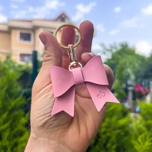 Pink PU leather bow keychain sweet bag charm with gold hardware and embossed detail.