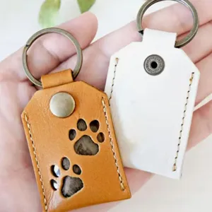 Close-up detail of cute pet fur storage keychain, PU leather paw print pendant design.
