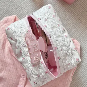 Gesteppte Blumen Kosmetiktasche mit eleganter weißer Spitzenborte und rosa Schleife für Makeup.
