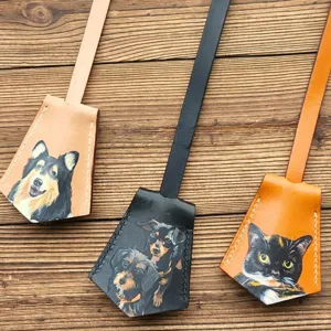 Detailed view of handmade leather pet luggage tags featuring hand-painted dogs and cats.