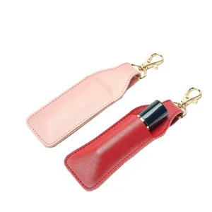 Detailed view of portable PU leather lipstick cases with keychain clips in pink and red colors.
